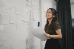 woman using a whiteboard to brainstorm notes